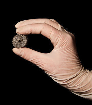 hand in glove holding titanium sponge