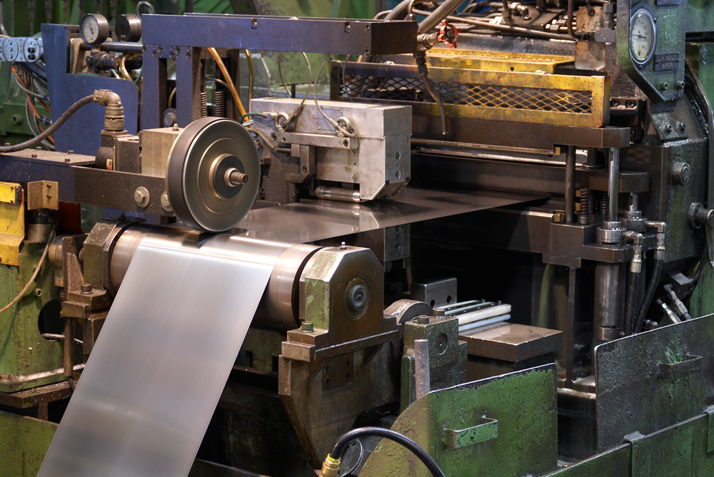 Metal strip running through re-roll mill at Ulbrich