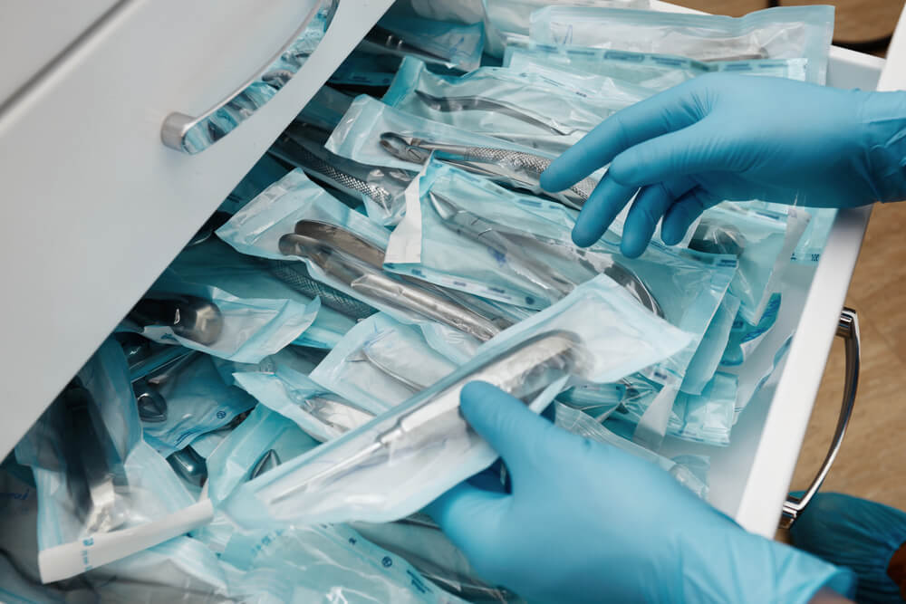 Medical laboratory technician holding a set of sterile disposable instruments