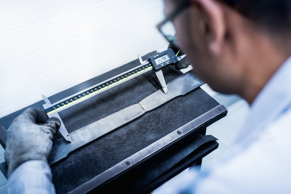 Engineer performing tensile test on material for elongation